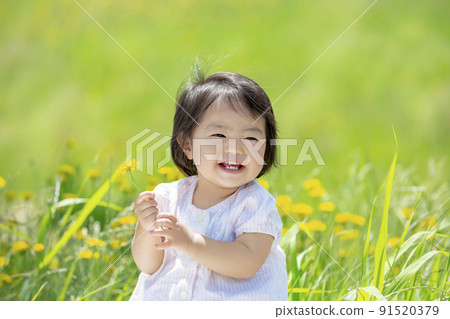 A girl playing in a park with wild flowers 91520379