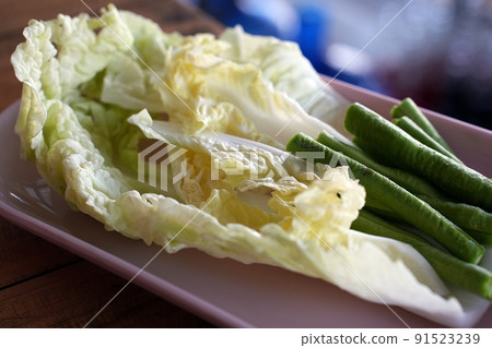 Selected focus Vegetable side dishes on pink disk and blurred paper background Selected focus Vegetable side dishes on pink disk and blurred paper background 91523239