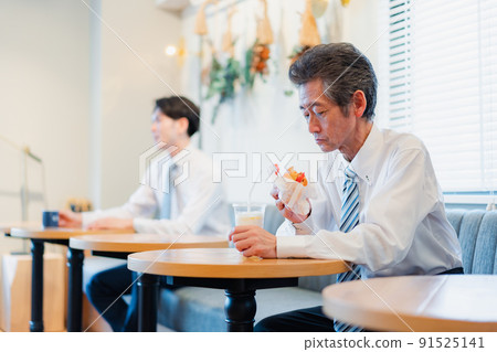 A businessman eating lunch at a hamburger shop 91525141