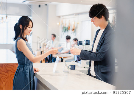 年輕女子在收銀台用信用卡付款 91525507