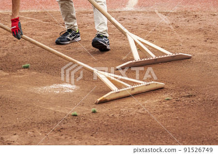 Ground maintenance using dragonfly rake to level the ground at a baseball field Ground maintenance using dragonfly rake to level the ground at a baseball field 91526749