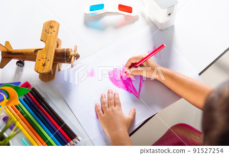 Happy child little girl colorful drawing pink heart on white paper 91527254