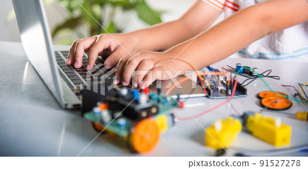 Asian kid boy learns coding and programming with laptop for Arduino robot car Asian kid boy learns coding and programming with laptop for Arduino robot car 91527278