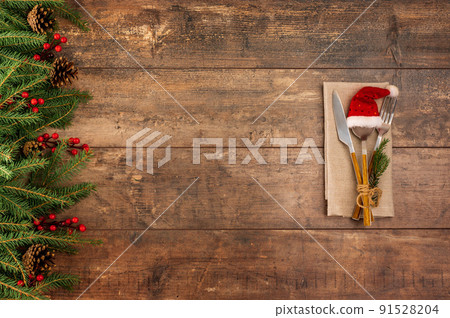 Festive New Year Christmas dinner concept. Christmas decorations and Cutlery on dark rustic table. Christmas table place setting. Winter holidays background. Top view, flat lay Festive New Year Christmas dinner concept. Christmas decorations and Cutlery on dark rustic table. Christmas table place setting. Winter holidays background. Top view, flat lay 91528204