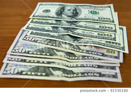 Thick wad of money cash on table Thick wad of money cash on table 91530180