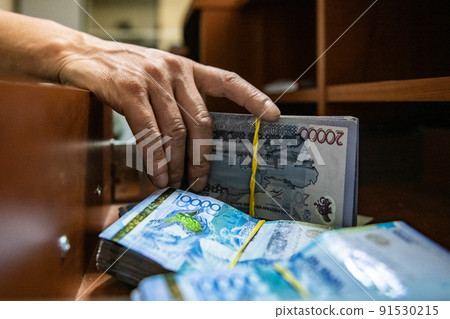 Thick wad of money cash on table 91530215