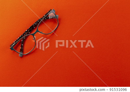 Stylish eyeglasses over orange background. Glasses selection, eye test 91531096