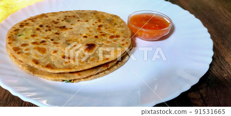 Aloo parantha an ideal indian breakfast served with tomato sauce Aloo parantha an ideal indian breakfast served with tomato sauce 91531665
