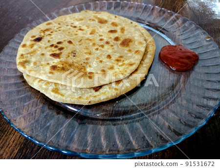 Aloo parantha an ideal indian breakfast served with tomato sauce Aloo parantha an ideal indian breakfast served with tomato sauce 91531672