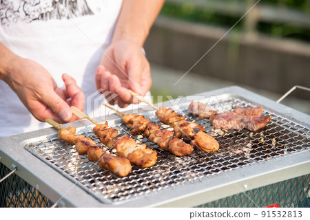 A man grilling yakitori on BBQ 91532813