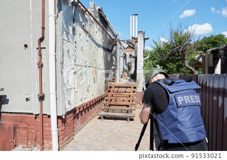 War correspondent photographs destroyed buildings after the bombing in Ukraine. War in Ukraine. 91533021