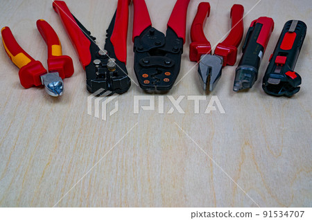 Red professional electrician tools on plywood background. 91534707