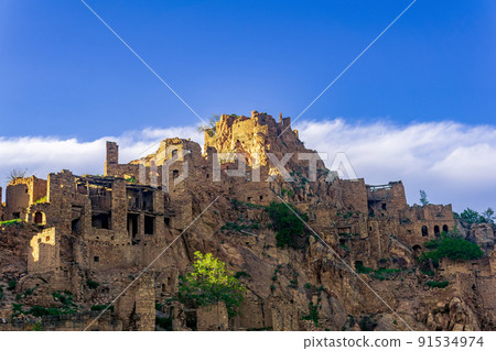 evening view of the abandoned village (aul) Gamsutl on top of a mountain in Dagestan 91534974