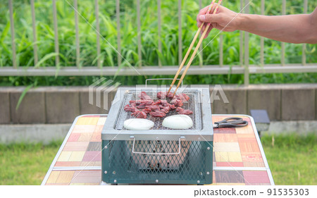 一個人在燒烤架上烤牛肉的手 一個人在燒烤架上烤牛肉的手 91535303