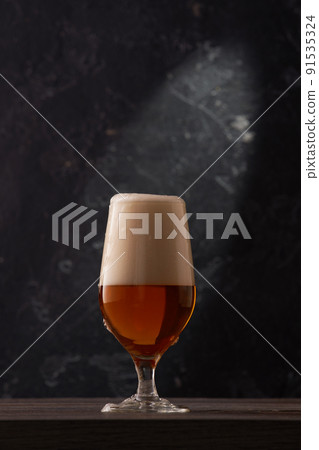 Tulip glass of beer on black background. 91535324