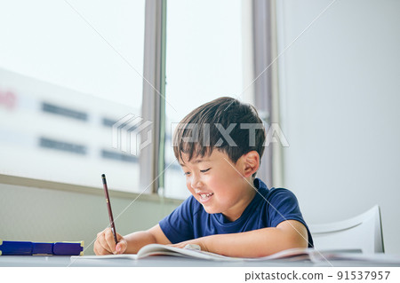 Elementary school boy writing in a notebook Elementary school boy writing in a notebook 91537957
