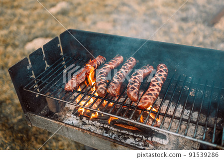 Delicious sausage on grill with spices and herbs on the flaming grill. Selective focus. 91539286