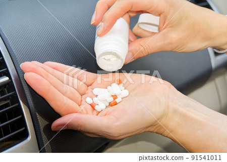 Women in car take anti stress pills. Women taking tablets inside his car. 91541011