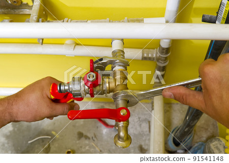 connecting plumbing fittings with keys. The plumber assembles a new water connection to the sink. 91541148