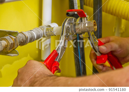 connecting plumbing fittings with keys. The plumber assembles a new water connection to the sink. 91541180