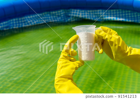 addition of chlorine powder for the pool to remove algae and disinfect water. inflatable swimming pool care concept. 91541213