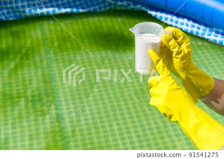 addition of chlorine powder for the pool to remove algae and disinfect water. inflatable swimming pool care concept. 91541275