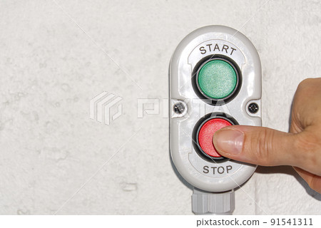 A finger pushing a stop button on production. A finger pushing a stop button on production. 91541311