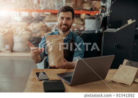 Business owner propose roasted coffee beans in paper bag in coffee factory ready for sale Business owner propose roasted coffee beans in paper bag in coffee factory ready for sale 91541892