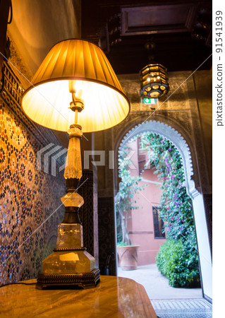 摩洛哥馬拉喀什的一家歷史悠久的酒店，色彩繽紛的瓷磚走廊通向外面，還有檯燈 91541939