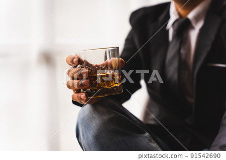 Businessman wearing suit sits in the luxury bar in gentlemen club and drink whiskey. 91542690