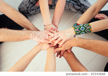 happy group of people practicing yoga in the studio. groups of meditation and support in the yoga class. the concept of group meditation and teamwork. hands close-up. Support Group 91543686