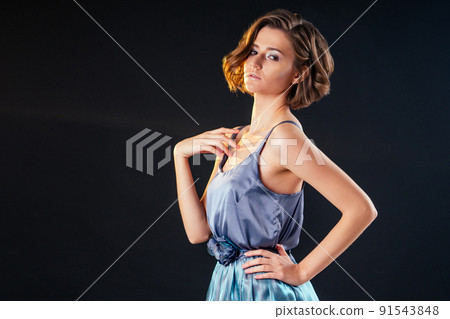 portrait of a young woman in windy blue dress. Beautiful girl with creative make-up and short haircut hairstyle 91543848