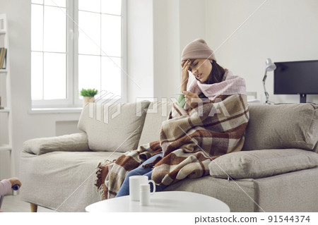 Sick woman who has fever looks frustrated at thermometer which again shows high temperature. Sick woman who has fever looks frustrated at thermometer which again shows high temperature. 91544374
