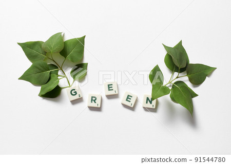 Green formed of scrabble tiles with tree branches. 91544780