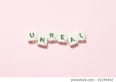 Unreal formed of scrabble tiles on pink background. 91544842