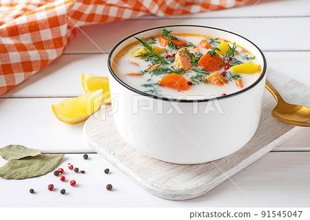 Lohikeitto, Finnish creamy salmon soup in a white bowl 91545047