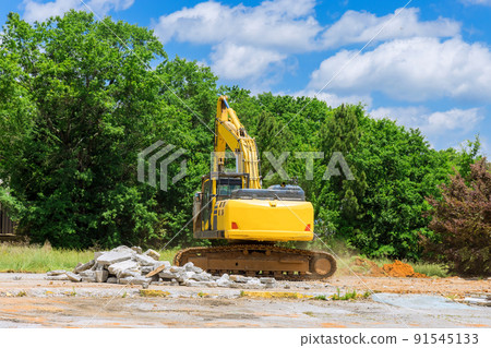 Excavator on a construction site cuts and crumbles old concrete crusher 91545133