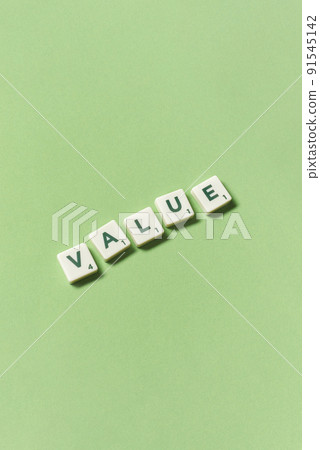 Value formed of scrabble blocks on green background. Value formed of scrabble blocks on green background. 91545142