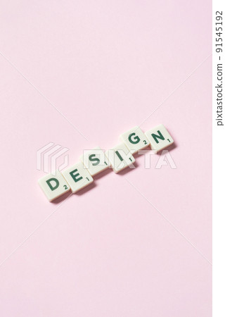 Design formed of scrabble blocks on pink background. 91545192
