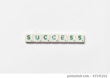 Success formed of scrabble tiles on white background. 91545201