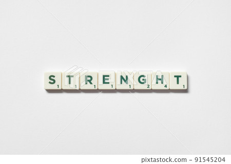 Strength formed of scrabble tiles on white background. 91545204