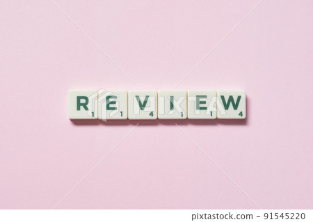 Review formed of scrabble blocks on pink background. Review formed of scrabble blocks on pink background. 91545220