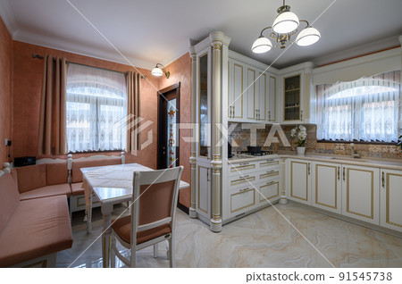 White classic cozy kitchen and dining room in city house 91545738