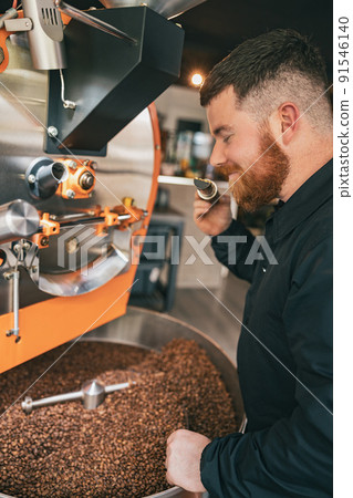 Close up of barista inhaling the aroma of coffee beans in own manufacturing Close up of barista inhaling the aroma of coffee beans in own manufacturing 91546140