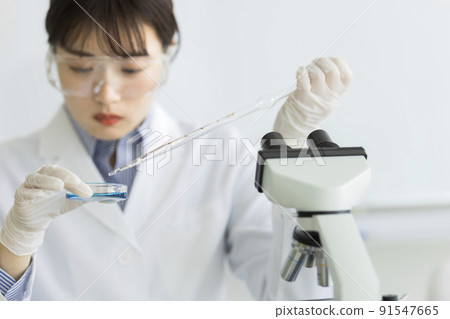 Female experiment in a white coat doing research 91547665