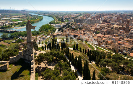 Aerial cityscape of Tudela with view of large Jesus statue 91548866