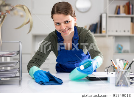 Woman cleaner polishing table in office Woman cleaner polishing table in office 91549018