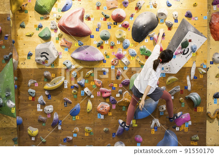 Young woman bouldering Young woman bouldering 91550170