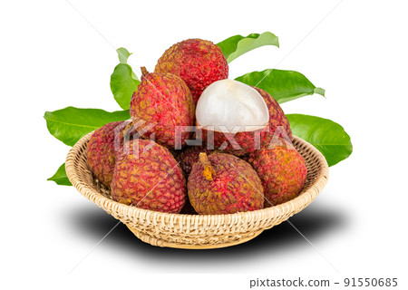 Pile of ripe lychee with green leaves in bamboo basket isolated on white background. 91550685