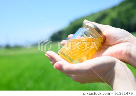 Bottled honey in my hand 91551479